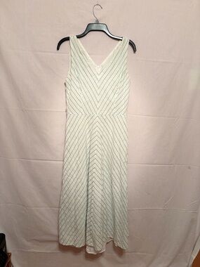 White, sleeveless V-neck maxi dress with chevron pattern of tiny green dots.